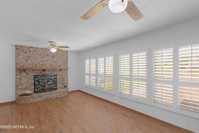 3344 Queen Ann Ln, Jacksonville, FL 32257 - unfurnished living room featuring ceiling fan, a textured ceiling, wood finished floors, and a brick fireplace