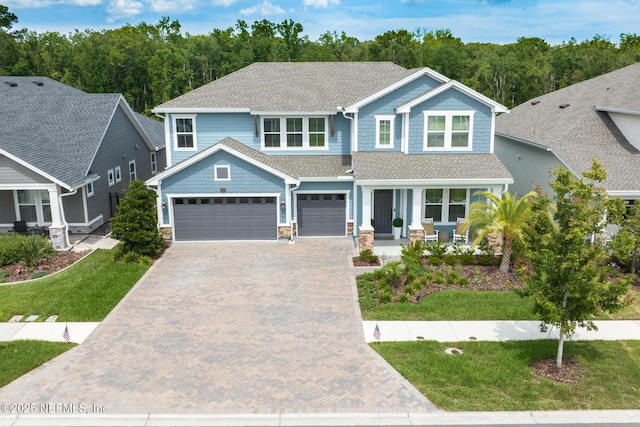843 Windley Dr, Saint Augustine, FL 32092 - craftsman inspired home with covered porch, decorative driveway, a front yard, roof with shingles, and stone siding