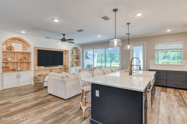843 Windley Dr, Saint Augustine, FL 32092 - kitchen with a kitchen bar, light wood finished floors, light countertops, a center island with sink, and recessed lighting