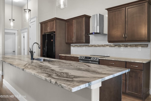 11 Woodstone Ln, Palm Coast, FL 32164 - kitchen with wall chimney exhaust hood, stainless steel range with electric cooktop, black refrigerator with ice dispenser, a sink, and light wood finished floors