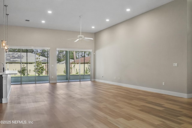 11 Woodstone Ln, Palm Coast, FL 32164 - spare room featuring a ceiling fan, baseboards, recessed lighting, wood finished floors, and a high ceiling