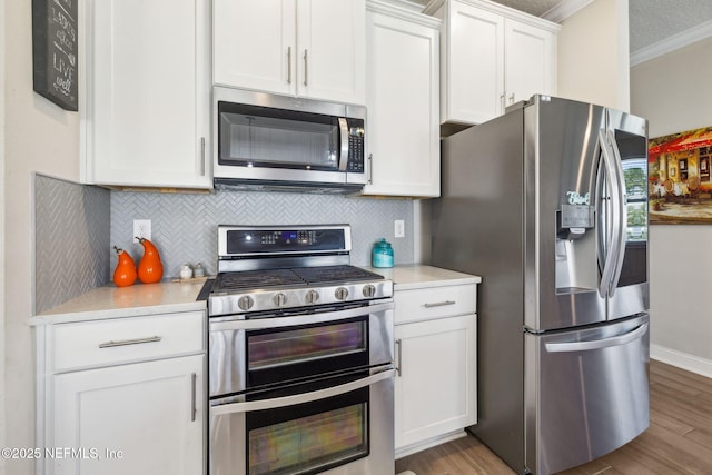 70 Creekmore Dr, Saint Augustine, FL 32092 - kitchen featuring stainless steel appliances, ornamental molding, light countertops, white cabinets, and tasteful backsplash