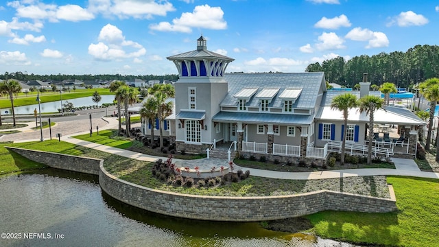 70 Creekmore Dr, Saint Augustine, FL 32092 - rear view of house with a metal roof, a water view, covered porch, stucco siding, and a standing seam roof