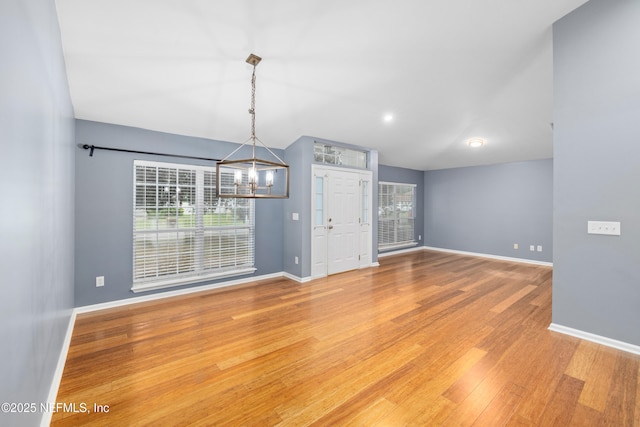 2007 Hollington Dr, Jacksonville, FL 32246 - spare room with a chandelier, baseboards, wood finished floors, and lofted ceiling