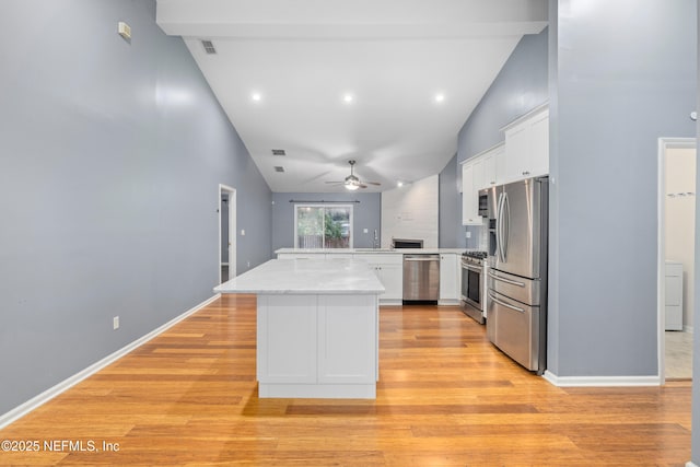 2007 Hollington Dr, Jacksonville, FL 32246 - kitchen with appliances with stainless steel finishes, vaulted ceiling, a ceiling fan, light wood-style floors, and white cabinets
