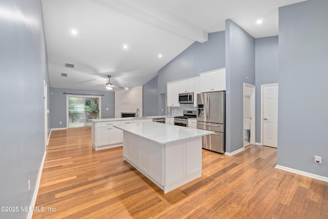 2007 Hollington Dr, Jacksonville, FL 32246 - kitchen featuring stainless steel appliances, a peninsula, a ceiling fan, beam ceiling, and light wood-type flooring