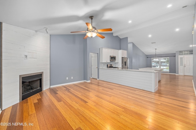 2007 Hollington Dr, Jacksonville, FL 32246 - unfurnished living room with a fireplace, light wood-style flooring, a ceiling fan, and baseboards