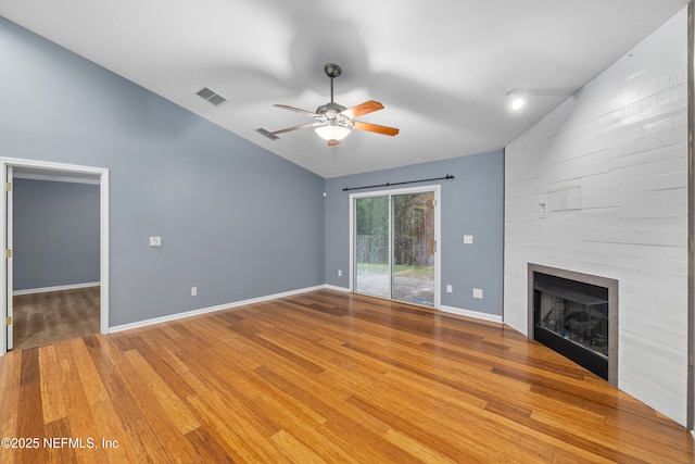 2007 Hollington Dr, Jacksonville, FL 32246 - unfurnished living room with vaulted ceiling, a ceiling fan, a large fireplace, light wood-style flooring, and baseboards
