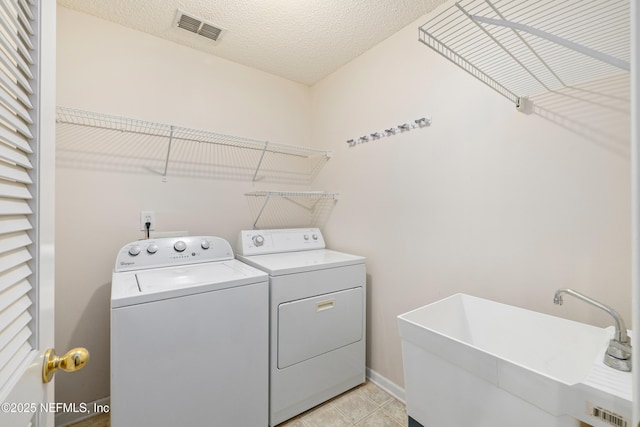 2007 Hollington Dr, Jacksonville, FL 32246 - laundry area with washer and clothes dryer, light tile patterned floors, and a textured ceiling