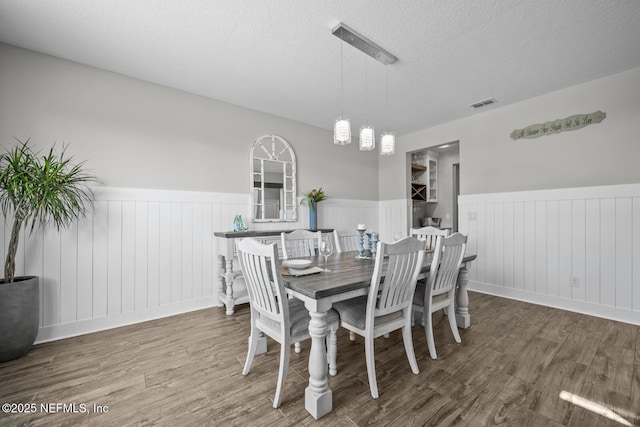 83 Tortola Way, Saint Johns, FL 32259 - dining space with a wainscoted wall, wood finished floors, a textured ceiling, and a decorative wall
