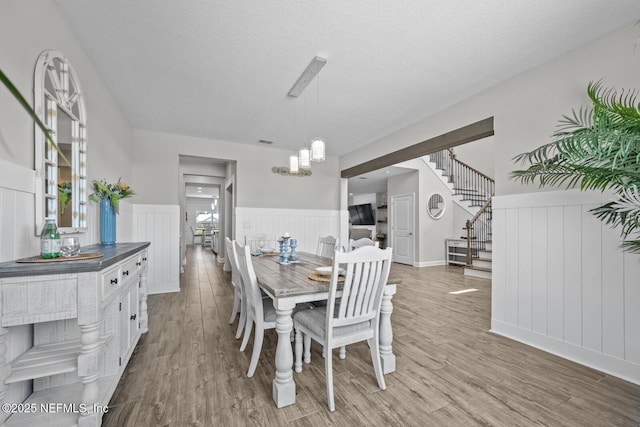 83 Tortola Way, Saint Johns, FL 32259 - dining area with a wainscoted wall, stairway, a chandelier, light wood-style floors, and a textured ceiling