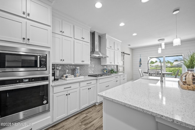 83 Tortola Way, Saint Johns, FL 32259 - kitchen featuring stainless steel appliances, wall chimney exhaust hood, tasteful backsplash, white cabinets, and recessed lighting