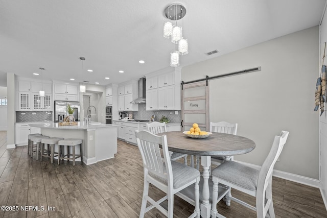 83 Tortola Way, Saint Johns, FL 32259 - dining area with a barn door, dark wood finished floors, and recessed lighting