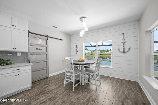 83 Tortola Way, Saint Johns, FL 32259 - dining space featuring a barn door, dark wood-style flooring, and a textured ceiling