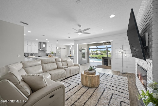 83 Tortola Way, Saint Johns, FL 32259 - living area featuring light wood-style flooring, a brick fireplace, ceiling fan, a textured ceiling, and recessed lighting