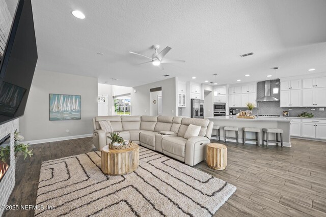 83 Tortola Way, Saint Johns, FL 32259 - living area featuring ceiling fan, a glass covered fireplace, light wood-type flooring, a textured ceiling, and recessed lighting