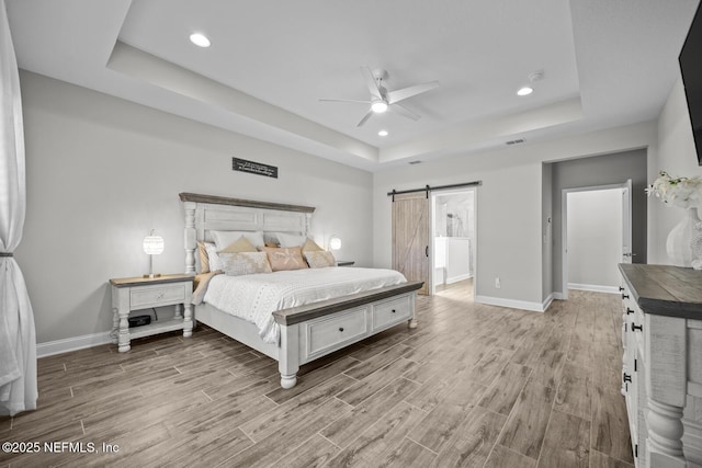 83 Tortola Way, Saint Johns, FL 32259 - bedroom featuring a tray ceiling, light wood finished floors, a barn door, recessed lighting, and ceiling fan