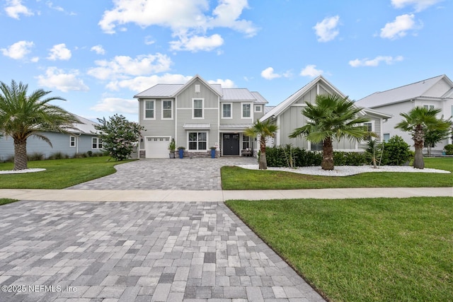 83 Tortola Way, Saint Johns, FL 32259 - view of front of home featuring board and batten siding, decorative driveway, a garage, a front yard, and a metal roof