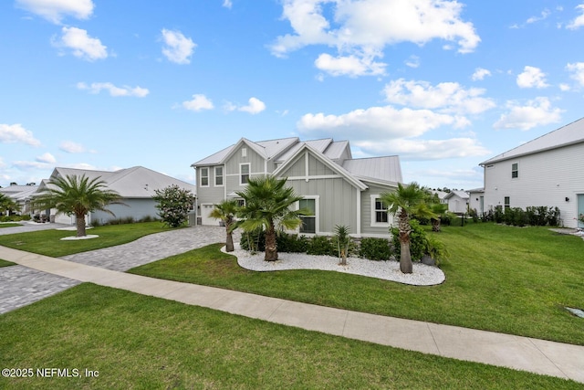 83 Tortola Way, Saint Johns, FL 32259 - view of front facade featuring board and batten siding, decorative driveway, a front yard, and an attached garage