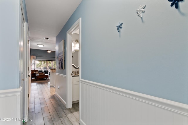 97 Village Las Palmas Cir, Saint Augustine, FL 32080 - hallway with a wainscoted wall and light wood-type flooring