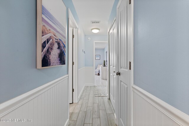 97 Village Las Palmas Cir, Saint Augustine, FL 32080 - hallway featuring a wainscoted wall and light wood-type flooring