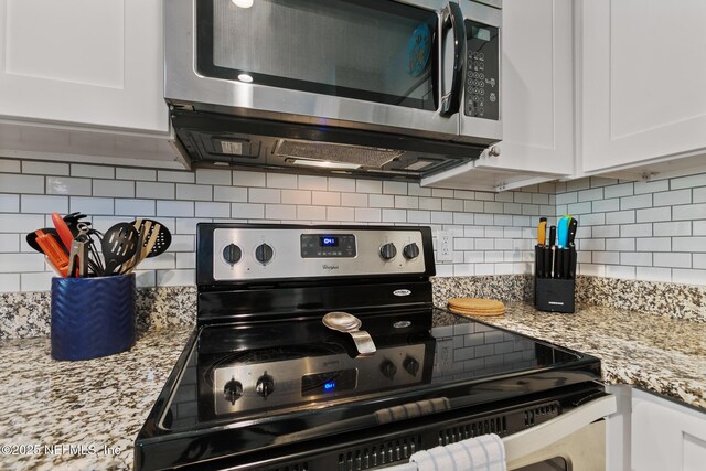 97 Village Las Palmas Cir, Saint Augustine, FL 32080 - kitchen with appliances with stainless steel finishes, tasteful backsplash, white cabinetry, and light stone counters