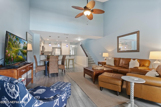 97 Village Las Palmas Cir, Saint Augustine, FL 32080 - living area with a towering ceiling, stairway, a ceiling fan, and light wood finished floors