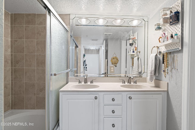 108 Laguna Villas Blvd Unit D22, Jacksonville Beach, FL 32250 - bathroom featuring a textured ceiling, double vanity, and bath / shower combo with glass door