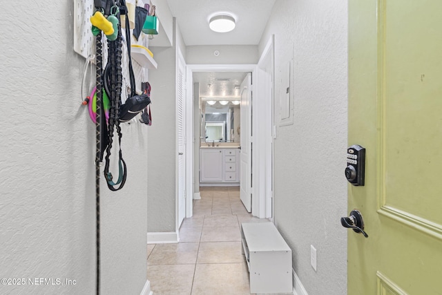 108 Laguna Villas Blvd Unit D22, Jacksonville Beach, FL 32250 - hallway with a textured wall, light tile patterned flooring, and baseboards