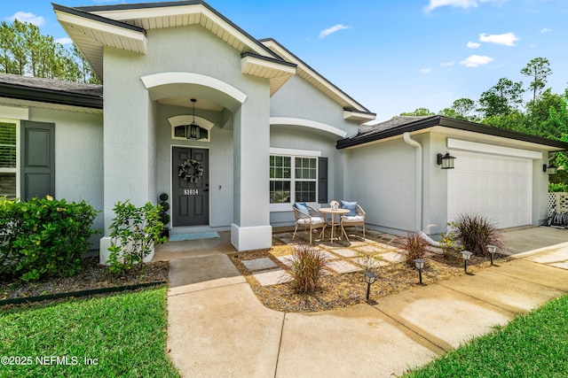 81014 Lockhaven Dr, Yulee, FL 32097 - property entrance featuring an attached garage, stucco siding, driveway, and a porch