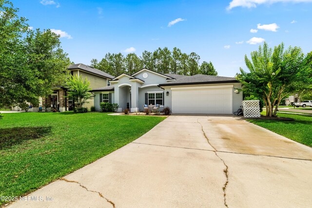 81014 Lockhaven Dr, Yulee, FL 32097 - ranch-style home featuring stucco siding, a garage, driveway, and a front yard