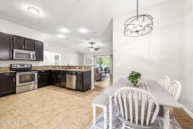 81014 Lockhaven Dr, Yulee, FL 32097 - kitchen with appliances with stainless steel finishes, a ceiling fan, a peninsula, light stone countertops, and vaulted ceiling