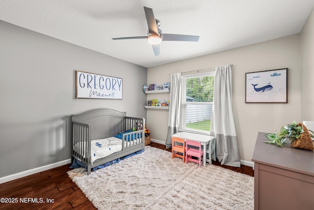 81014 Lockhaven Dr, Yulee, FL 32097 - bedroom with baseboards, a nursery area, dark wood-type flooring, and ceiling fan