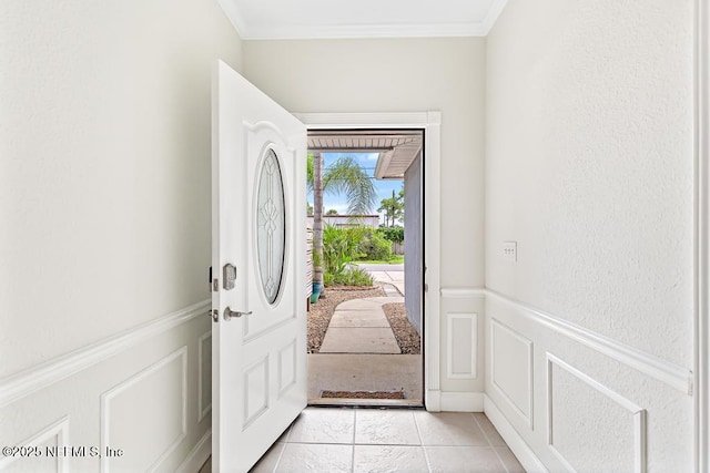 66 W 14th St, Atlantic Beach, FL 32233 - foyer entrance with crown molding, a decorative wall, a wainscoted wall, and light tile patterned floors