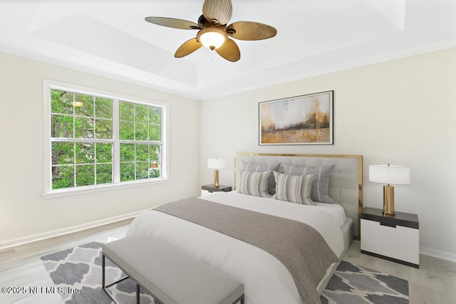 66 W 14th St, Atlantic Beach, FL 32233 - bedroom featuring a raised ceiling, light wood-type flooring, baseboards, and a ceiling fan
