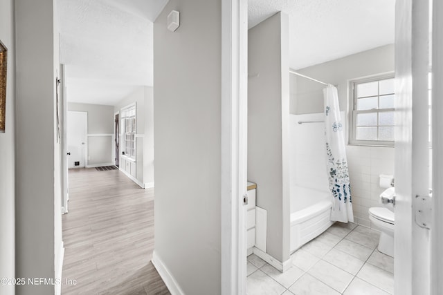 10836 Hawaii Dr S, Jacksonville, FL 32246 - full bath with toilet, shower / bath combination with curtain, a textured ceiling, baseboards, and wood finished floors