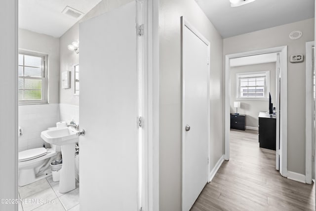 10836 Hawaii Dr S, Jacksonville, FL 32246 - bathroom with healthy amount of natural light, toilet, wood finished floors, tile walls, and baseboards