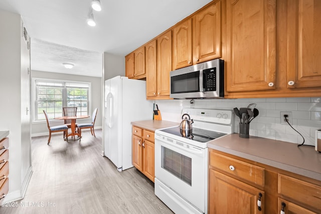 10836 Hawaii Dr S, Jacksonville, FL 32246 - kitchen with white appliances, tasteful backsplash, baseboards, and light wood-style floors