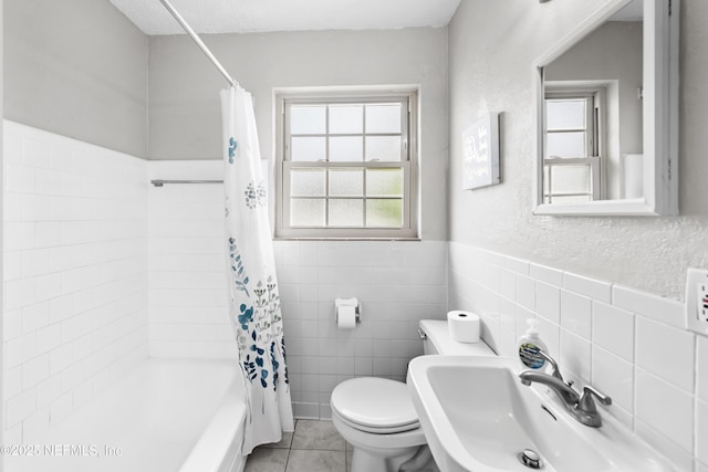 10836 Hawaii Dr S, Jacksonville, FL 32246 - bathroom featuring a sink, toilet, tile walls, shower / bathtub combination with curtain, and a wainscoted wall