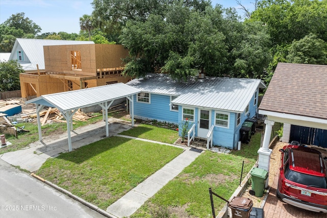 82 Kings Ferry Way, Saint Augustine, FL 32084 - view of front of property with a front yard, metal roof, entry steps, and a carport