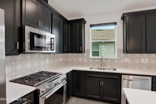 564 Jubilee Cir, Yulee, FL 32097 - kitchen with stainless steel appliances, light countertops, dark cabinetry, and backsplash