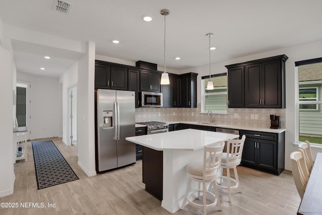 564 Jubilee Cir, Yulee, FL 32097 - kitchen with appliances with stainless steel finishes, decorative backsplash, a center island, light wood-style flooring, and recessed lighting