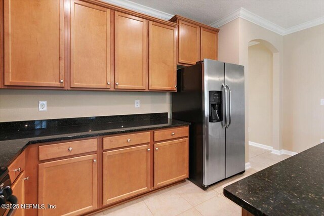 165 Crown Colony Rd, Saint Augustine, FL 32092 - kitchen featuring stainless steel fridge with ice dispenser, ornamental molding, light tile patterned floors, arched walkways, and dark stone countertops