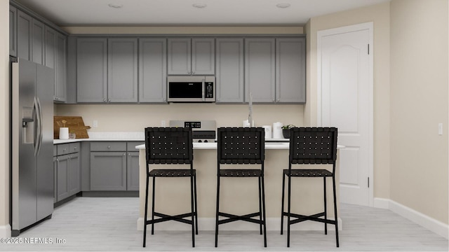 527 Superior Blvd, Saint Johns, FL 32092 - kitchen featuring stainless steel fridge, white microwave, range, gray cabinets, and light wood finished floors