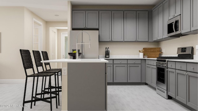 527 Superior Blvd, Saint Johns, FL 32092 - kitchen featuring stainless steel range with gas stovetop, gray cabinetry, fridge with ice dispenser, light countertops, and a kitchen island