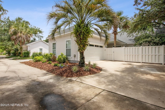 1885 Floyd St, Fernandina Beach, FL 32034 - view of side of home featuring concrete driveway, a garage, and a gate
