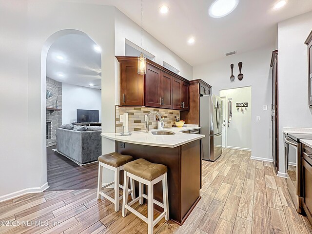 3923 Eden Estate Trl, Middleburg, FL 32068 - kitchen with stainless steel appliances, a sink, light wood-style flooring, tasteful backsplash, and light countertops