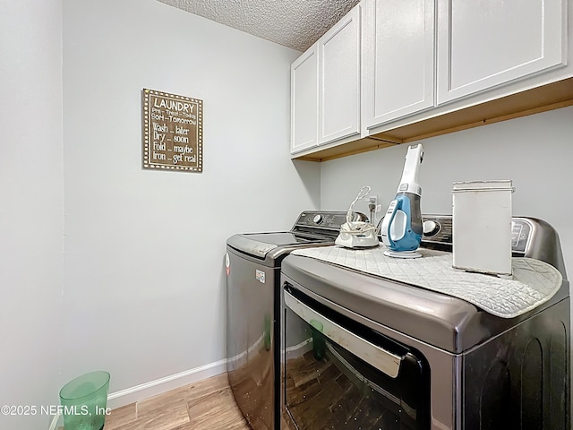 3923 Eden Estate Trl, Middleburg, FL 32068 - laundry room with washer and clothes dryer, cabinet space, light wood-style flooring, baseboards, and a textured ceiling