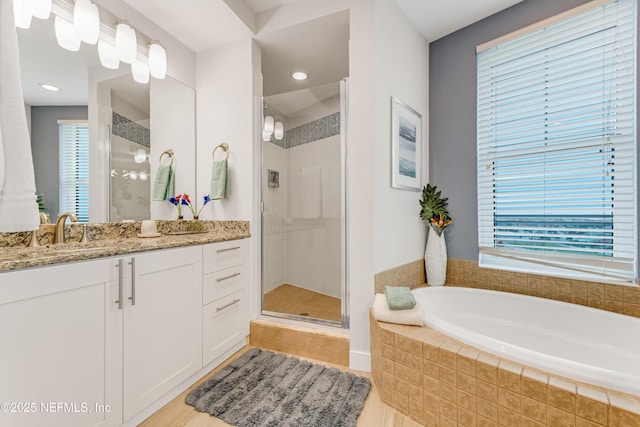 1925 S Atlantic Ave Unit 810, Daytona Beach Shores, FL 32118 - bathroom with vanity, a shower stall, a garden tub, and wood finished floors