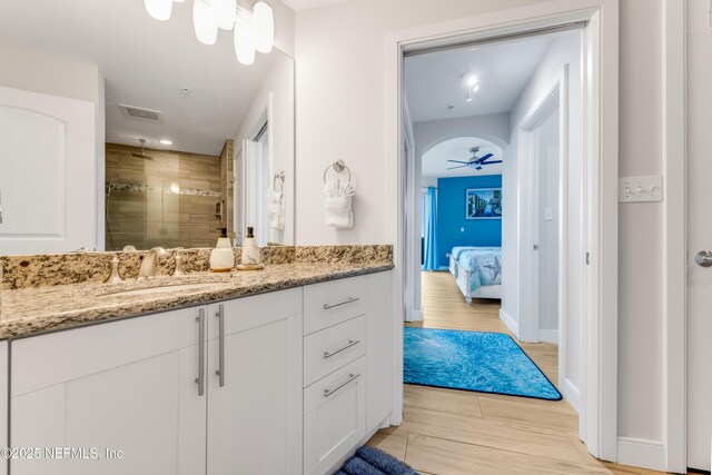 1925 S Atlantic Ave Unit 810, Daytona Beach Shores, FL 32118 - ensuite bathroom with wood finished floors, vanity, a tile shower, a ceiling fan, and baseboards
